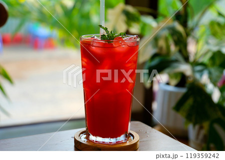 watermelon juice single-colored transparent cocktail, refreshing in a low glass with ice cubes and taste of berries, cherries, strawberries, greiprut. Side view. Isolated white background. Drink for 119359242