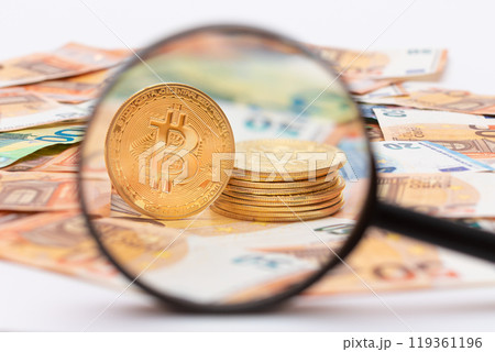A Stack of Bitcoin Coins Visible Through a Magnifying Glass on the 50-Euro Banknotes A Stack of Bitcoin Coins Visible Through a Magnifying Glass on the 50-Euro Banknotes 119361196
