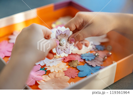 Small, colorful paper flowers in child hands, little girl creativing of 3D flowers. Child development toy Small, colorful paper flowers in child hands, little girl creativing of 3D flowers. Child development toy 119361964