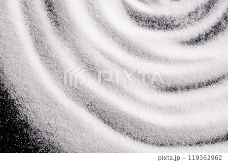 Finely ground stone white rock salt texture on black background, top view. 119362962