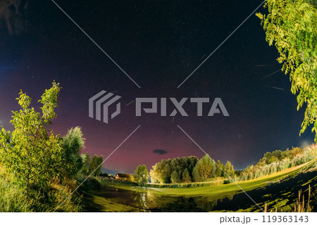 Aurora borealis Amazing Night Starry Sky above summer country landscape. Bright Dramatic Perseids meteors Trails Of Stars And Meteors. Sky In Different Colors. From Dusk Till Dawn. Misty Night. 119363143