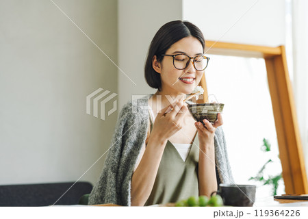 お茶碗でご飯を食べる若い女性 119364226