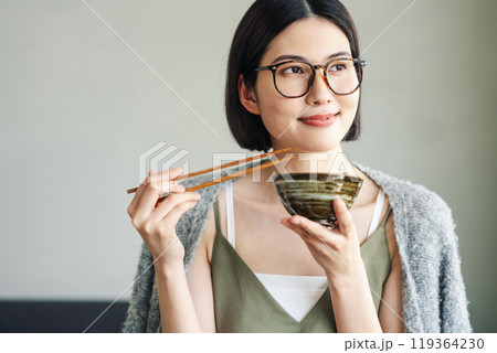 お茶碗でご飯を食べる若い女性 119364230