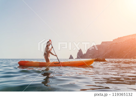 Kayaking Woman Sea - Woman kayaking on the ocean with a mountain in the background. Kayaking Woman Sea - Woman kayaking on the ocean with a mountain in the background. 119365132