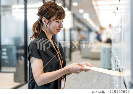 定形外郵便封筒を郵便受けに入れるビジネスパーソン 定形外郵便封筒を郵便受けに入れるビジネスパーソン 119365696