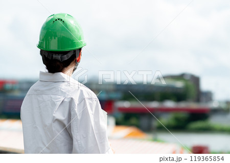 建設中の橋を見つめるヘルメットを被った作業服姿の女性 建設中の橋を見つめるヘルメットを被った作業服姿の女性 119365854