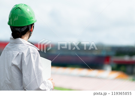 建設中の橋を見つめるヘルメットを被った作業服姿の女性 建設中の橋を見つめるヘルメットを被った作業服姿の女性 119365855