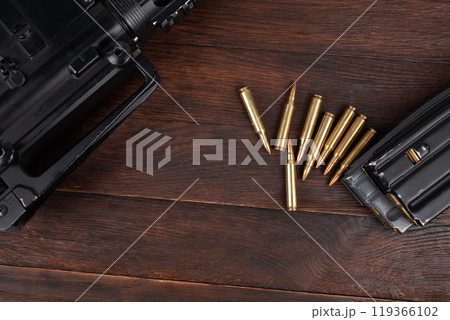 Rifle and Ammunition with magazine on wooden table 119366102