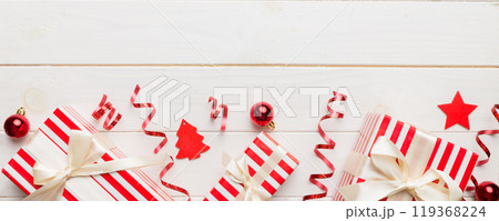 Holiday flat lay with gift boxes wrapped in colorful paper and tied decorated with confetti on colored background. Christmas, Birthday, Valentine and sale concept, top view 119368224
