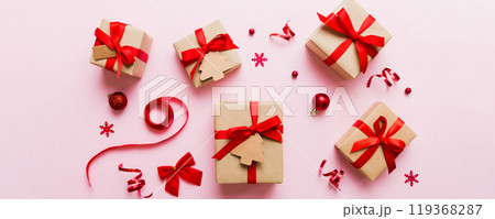 Christmas kraft gifts box with ribbon on colored background. Cozy Christmas still life, birthday or new year Christmas kraft gifts box with ribbon on colored background. Cozy Christmas still life, birthday or new year 119368287