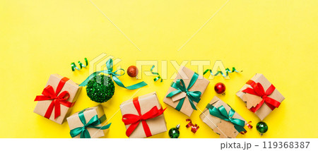 wrapped christmas or other holiday handmade present in paper with colored ribbon. Present box, decoration of gift on colourfull table, top view with copy space 119368387