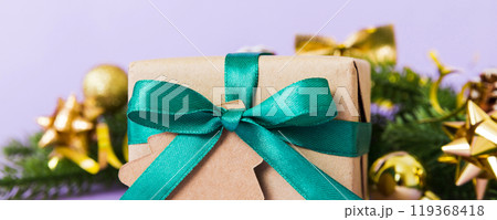 New Year Christmas mood, gift box, branches of a christmas tree, New Year decorations on a colored background 119368418