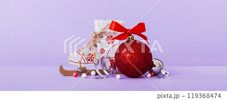 Christmas ball with skates on colored background. decoration bauble with ribbon bow with copy space Christmas ball with skates on colored background. decoration bauble with ribbon bow with copy space 119368474