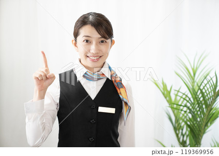 人差し指を立てて微笑む女性 119369956
