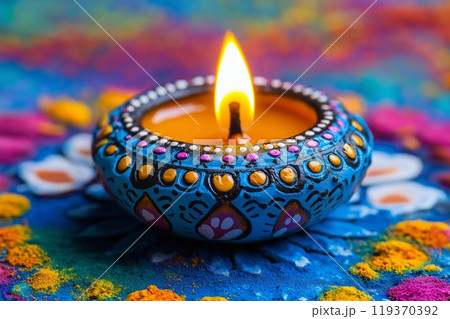 A beautifully painted diya with intricate designs, glowing brightly on a colorful floral background A beautifully painted diya with intricate designs, glowing brightly on a colorful floral background 119370392
