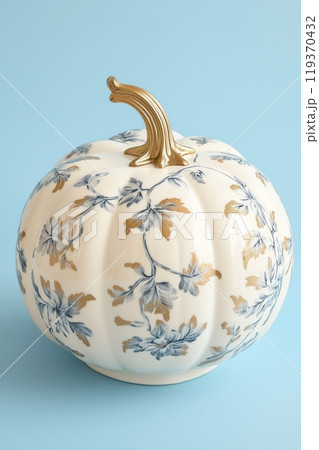 White pumpkin with delicate blue and gold floral patterns, featuring a smooth, shiny gold stem 119370432