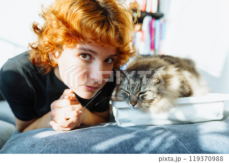 portrait red-haired attractive young woman with fluffy big cat portrait red-haired attractive young woman with fluffy big cat 119370988