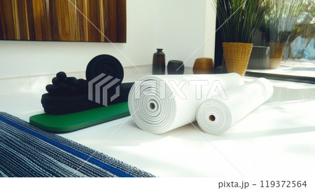 Rolled up yoga mats in a minimalist studio 119372564