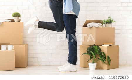Excited moving in. Cropped of happy couple in love having fun in new house, man lifting woman up, free space Excited moving in. Cropped of happy couple in love having fun in new house, man lifting woman up, free space 119372689