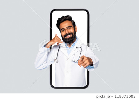 A smiling doctor in a white coat with a stethoscope is standing in a large smartphone. He is making a call me gesture with his left hand, and pointing at the viewer with his right. A smiling doctor in a white coat with a stethoscope is standing in a large smartphone. He is making a call me gesture with his left hand, and pointing at the viewer with his right. 119373005