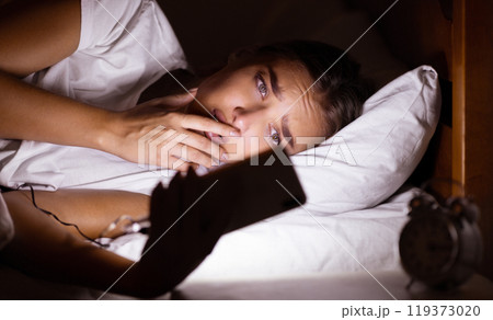 Insomnia And Anxiety. Stressed Girl Using Cellphone Browsing Internet Lying In Bed In Bedroom At Night. Low Light 119373020