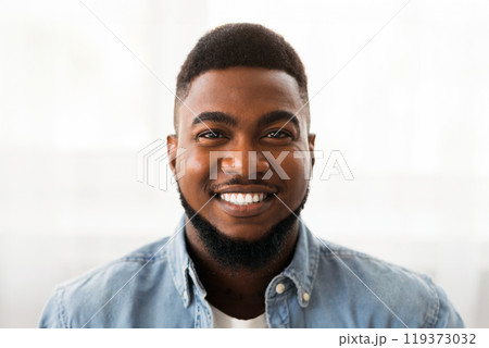 Closeup portrait of young attractive black guy with happy face expression, copy space 119373032