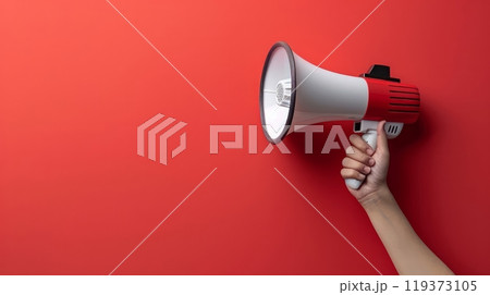 A hand holding a megaphone against red wall with copy space, AI 119373105
