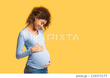 Enjoying pregnancy. Expectant woman embracing her belly over white background, panorama with free space 119373177