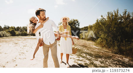 Summer Vacation. Family Having Fun Walking Outdoor, Father Lifting Little Daughter On Sunny Day On Weekend In Countryside. Summer Vacation. Family Having Fun Walking Outdoor, Father Lifting Little Daughter On Sunny Day On Weekend In Countryside. 119373274