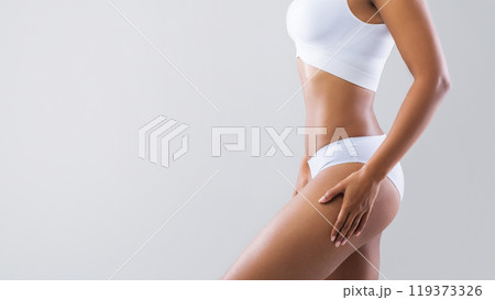 Beauty concept. Young afro woman showing her beautiful body over grey studio background with empty space, cropped 119373326