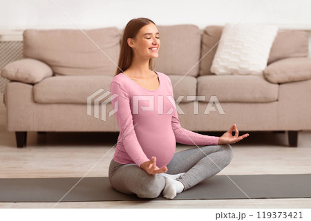 Staying Healthy And Safe During Pregnancy. Beautiful pregnant woman meditating on yoga mat. Copy space Staying Healthy And Safe During Pregnancy. Beautiful pregnant woman meditating on yoga mat. Copy space 119373421