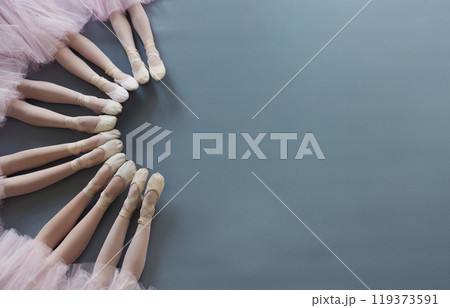 Ballet background. Little ballerinas legs in pointe shoes on floor, top view, copy space 119373591