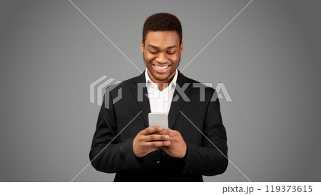 Online Chat. Happy black guy in suit using mobile phone, texting email to clients, white background, panorama Online Chat. Happy black guy in suit using mobile phone, texting email to clients, white background, panorama 119373615