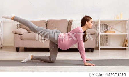 Prenatal Exercises For Healthy Delivery. Pregnant woman doing back leg raises or donkey kick on yoga mat. Copy space 119373616