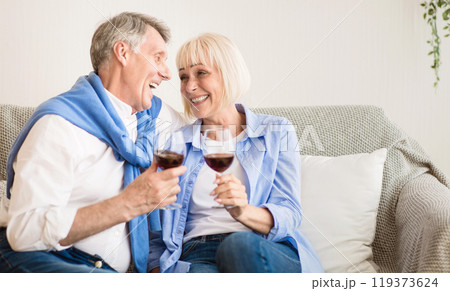 Loving mature couple drinking red wine, celebrating anniversary at home Loving mature couple drinking red wine, celebrating anniversary at home 119373624