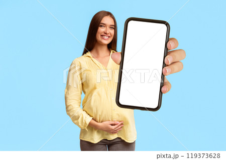 Like. Happy Pregnant Woman Gesturing Thumbs Up Touching Belly Standing Over Gray Background. Studio Shot 119373628