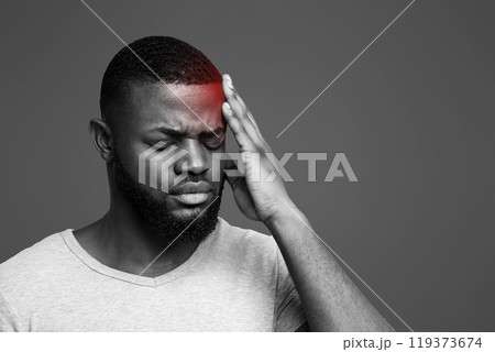 Young black man suffering from headache, touching highlighted forehead Young black man suffering from headache, touching highlighted forehead 119373674