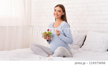 Pregnancy Healthy Diet. Pregnant Girl Holding Vegetable Salad In Bowl Smiling To Camera Sitting In Bed At Home. Empty Space 119373698