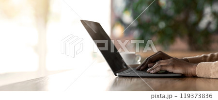 Hands of afro girl typing on laptop keyboard, having break, cafe interior, cropped, panorama Hands of afro girl typing on laptop keyboard, having break, cafe interior, cropped, panorama 119373836