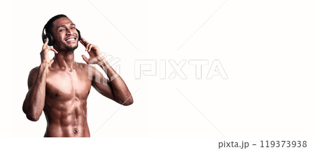 Fitness Playlist. Shirtless African Sporty Guy In Headphones Listening To Music Enjoying Favorite Song Over White Studio Background. Empty Space Fitness Playlist. Shirtless African Sporty Guy In Headphones Listening To Music Enjoying Favorite Song Over White Studio Background. Empty Space 119373938