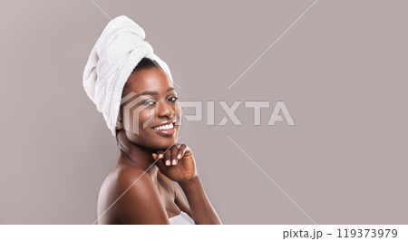 Beautiful african american woman after bath, smiling with white towel on head, empty space Beautiful african american woman after bath, smiling with white towel on head, empty space 119373979