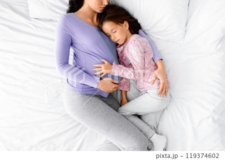 Peaceful image of expecting young woman having nap with little daughter at home, top view Peaceful image of expecting young woman having nap with little daughter at home, top view 119374602