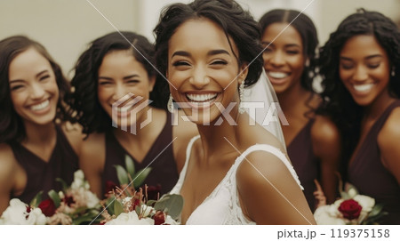 A radiant bride smiles broadly while surrounded by her cheerful bridesmaids, each holding flowers, showcasing joy and friendship in a picturesque outdoor setting. A radiant bride smiles broadly while surrounded by her cheerful bridesmaids, each holding flowers, showcasing joy and friendship in a picturesque outdoor setting. 119375158