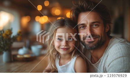 A dad and his young daughter smile at each other in a warm cafe, surrounded by soft lighting and cheerful decor, enjoying their quality time. 119376929