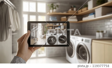 A person holds a tablet showcasing a beautifully designed laundry room featuring sleek appliances. 119377758
