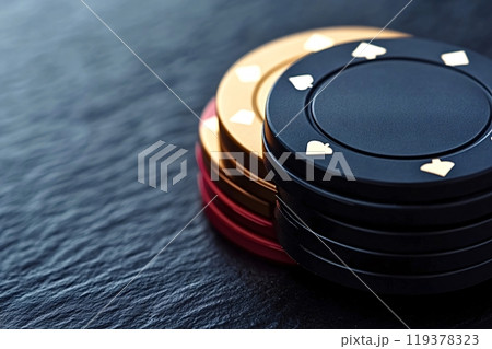 Stack of poker chips sitting on a slate table 119378323