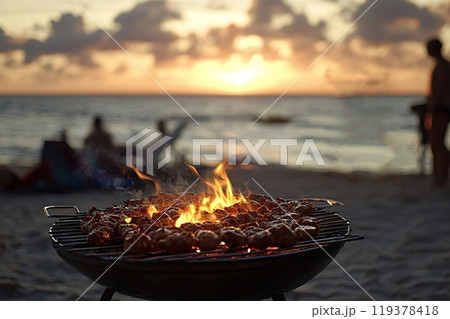 Grilling meat on barbecue with friends relaxing on beach at sunset 119378418
