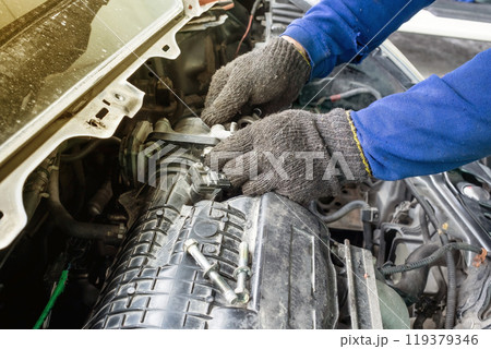 Hands of car mechanic/technician is repairing/checking and fixing Hands of car mechanic/technician is repairing/checking and fixing 119379346