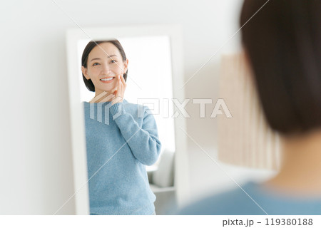鏡を見て微笑む40代女性 119380188