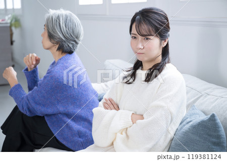 リビングで喧嘩する親子 母親と娘のイメージの上半身 リビングで喧嘩する親子 母親と娘のイメージの上半身 119381124
